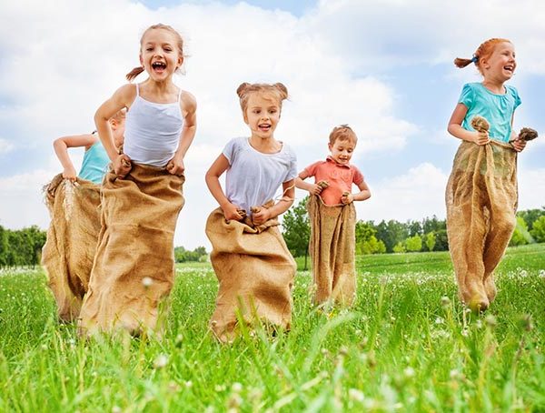 fotografía que muestra un ejemplo de entrenamiento de fuerza en niños - carrera de sacos