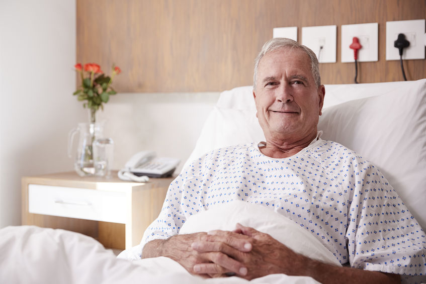 Hombre mayor recostado en cama de hospital